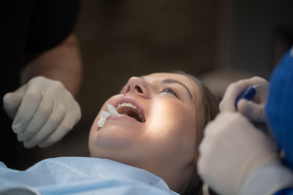 young woman with her mouth open receiving dental care