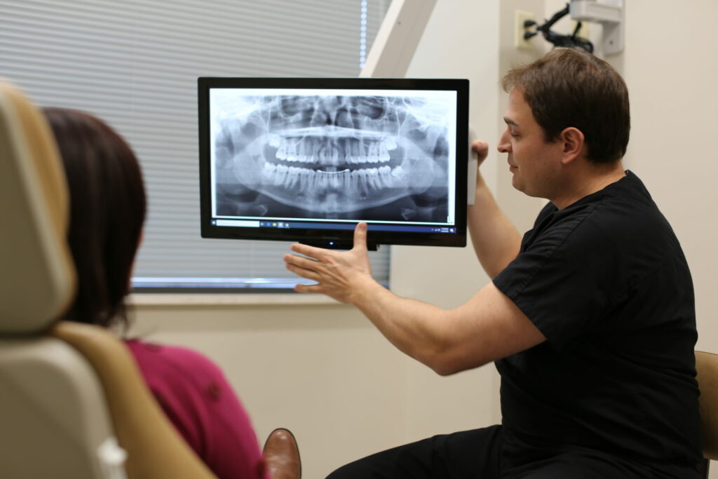 doctor showing a patient her dental x-rays and giving post operative instructions