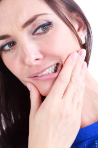 Woman with a tooth pain holding her jaw