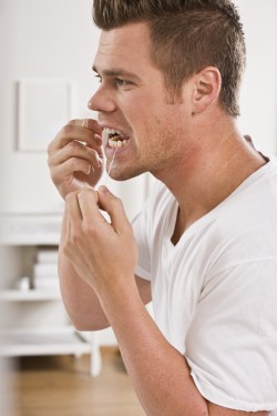 man taking care of his dental health by flossing his teeth
